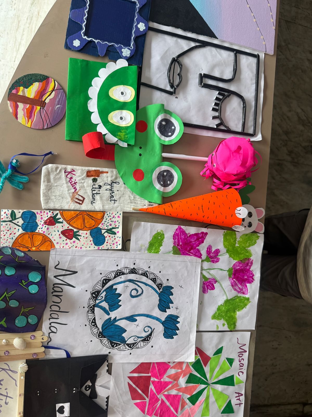 An overhead view of a table full of finished art and craft projects