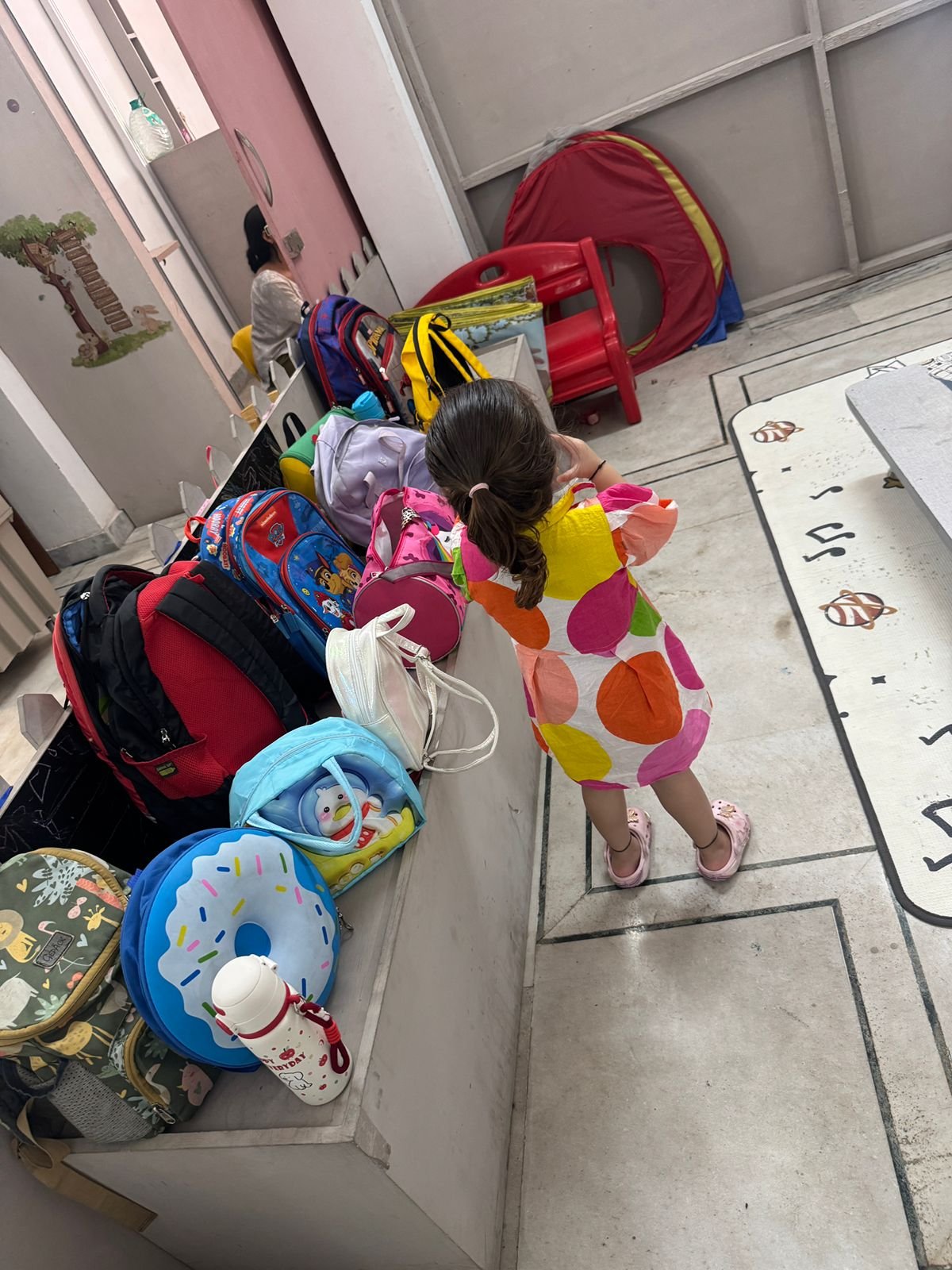A child at the bag shelf ready to head home after class